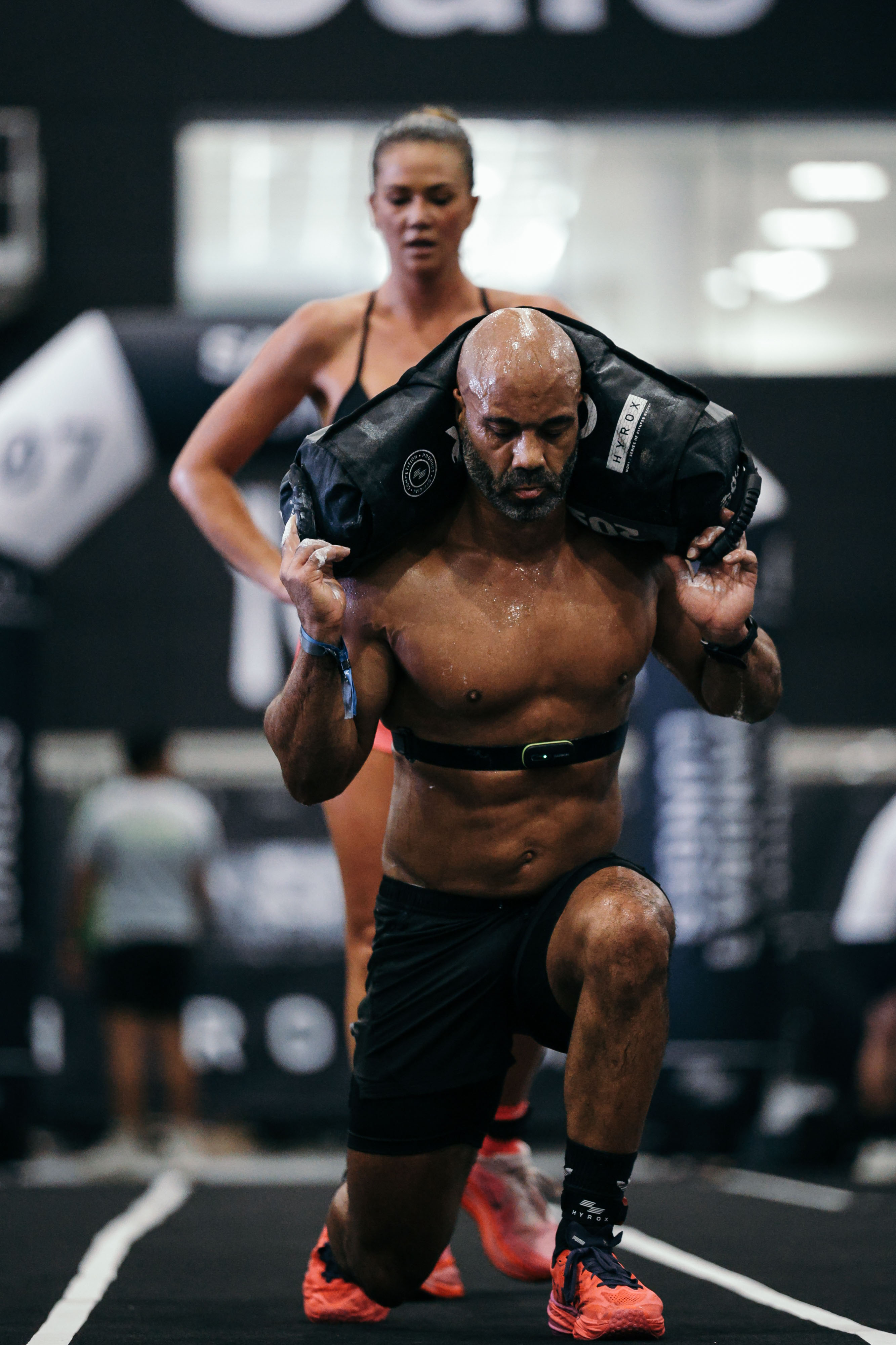 Erin racing a HYROX sandbag lunge